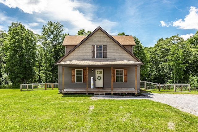 view of front of home with a porch, fence, driveway, and a front lawn