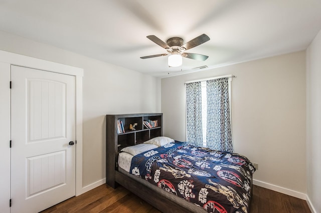 bedroom featuring a ceiling fan, dark wood-style flooring, visible vents, and baseboards