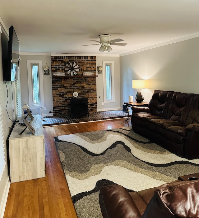 living room featuring ceiling fan, wood-type flooring, and crown molding