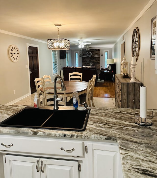 kitchen featuring light wood-type flooring, white cabinetry, crown molding, and sink