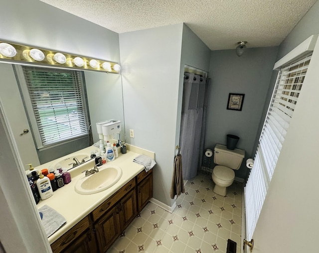 bathroom with vanity, a textured ceiling, and toilet