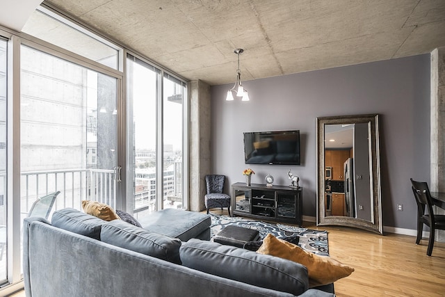 living room with hardwood / wood-style flooring, an inviting chandelier, and a wall of windows