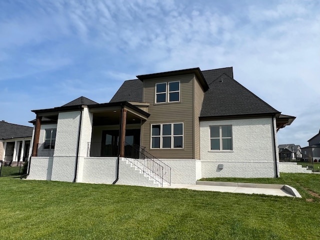 rear view of house featuring a yard