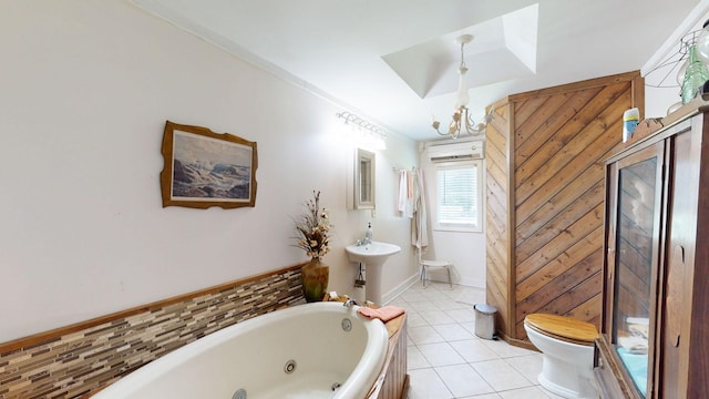 bathroom with tile patterned flooring, a notable chandelier, toilet, and a tub