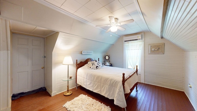 bedroom featuring a wall unit AC, ceiling fan, hardwood / wood-style floors, and vaulted ceiling