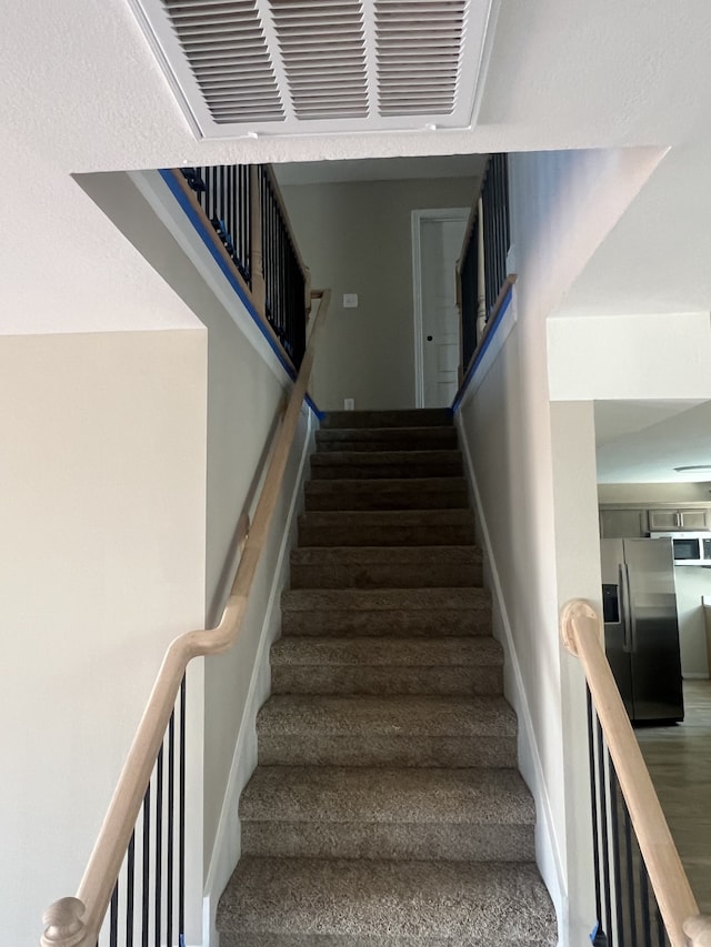 stairs featuring hardwood / wood-style flooring