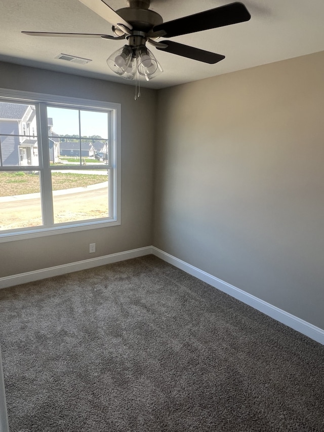 empty room featuring ceiling fan and carpet