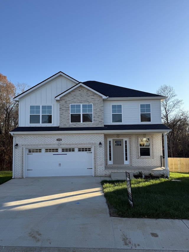 front facade featuring a front yard, a garage, and covered porch