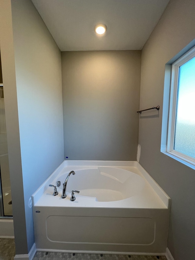 bathroom featuring plenty of natural light and independent shower and bath