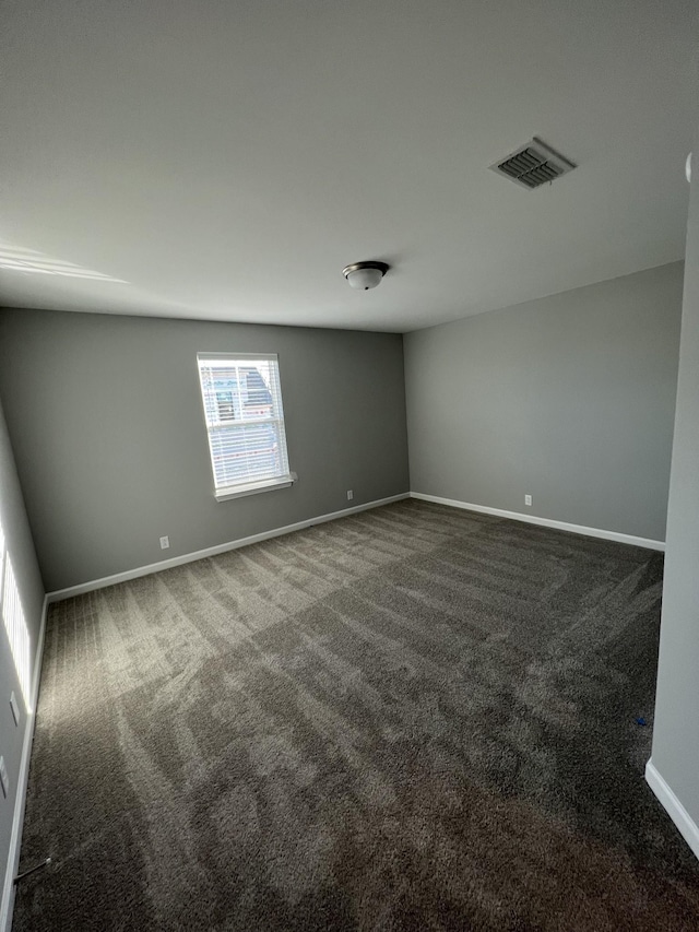 unfurnished room with dark colored carpet