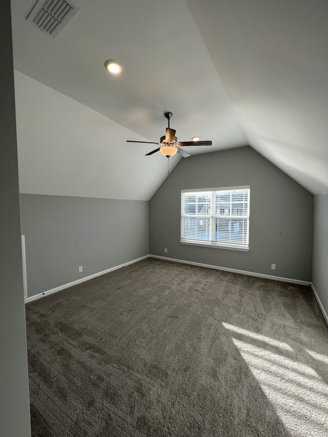 additional living space featuring lofted ceiling, dark carpet, and ceiling fan