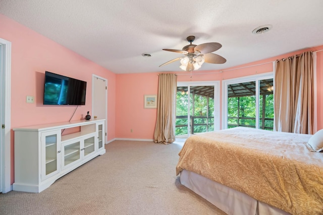 bedroom with a textured ceiling, ceiling fan, access to exterior, and light carpet