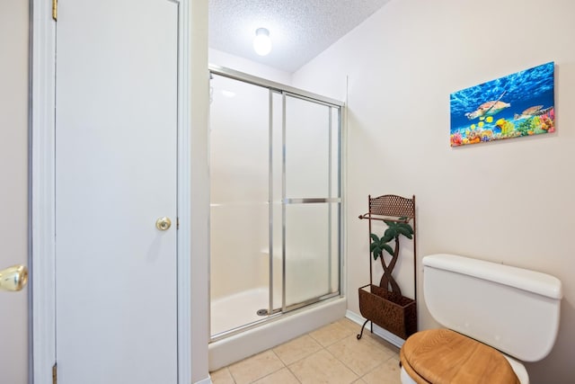 bathroom featuring a textured ceiling, tile patterned flooring, toilet, and walk in shower