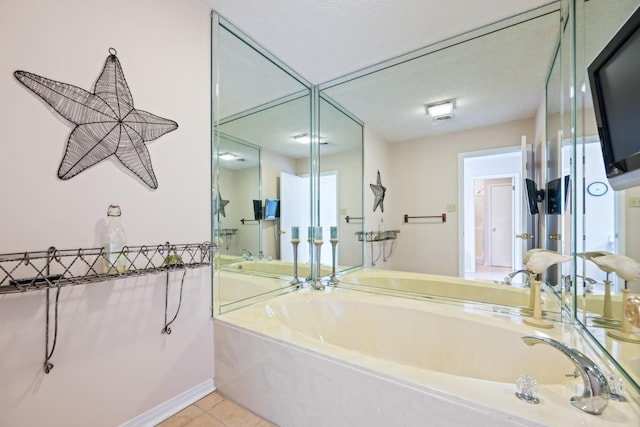 bathroom featuring tile patterned floors, a washtub, and a textured ceiling