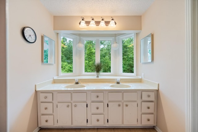 bathroom featuring tile patterned floors, vanity, and a textured ceiling