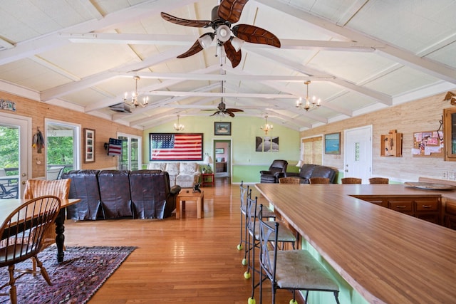 dining room with vaulted ceiling with beams, light hardwood / wood-style floors, and ceiling fan with notable chandelier