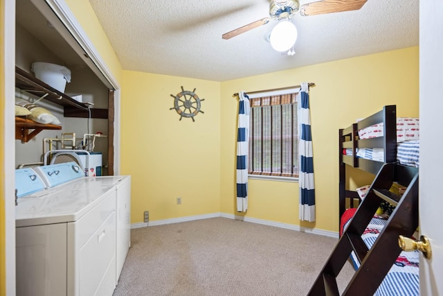 clothes washing area featuring light carpet, a textured ceiling, separate washer and dryer, and ceiling fan