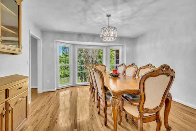 dining room with light hardwood / wood-style flooring and a chandelier