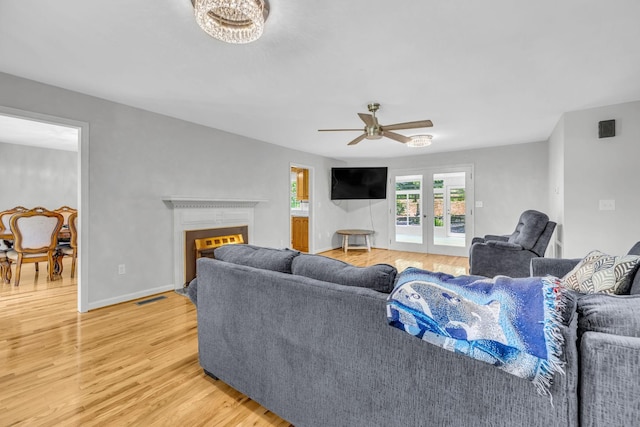 living room with ceiling fan, hardwood / wood-style floors, and french doors