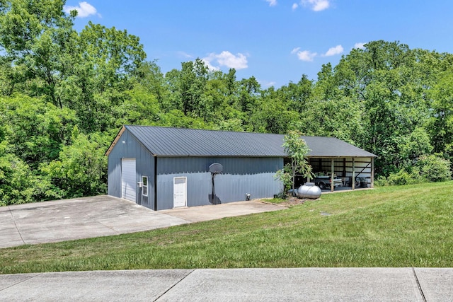 garage with a carport and a lawn