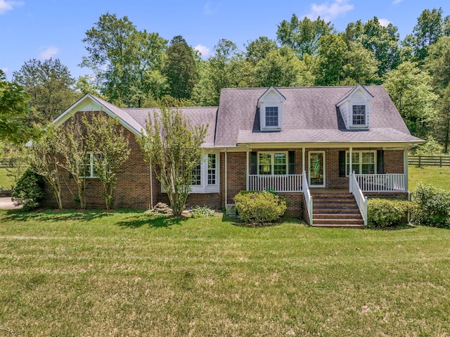 new england style home with covered porch and a front lawn