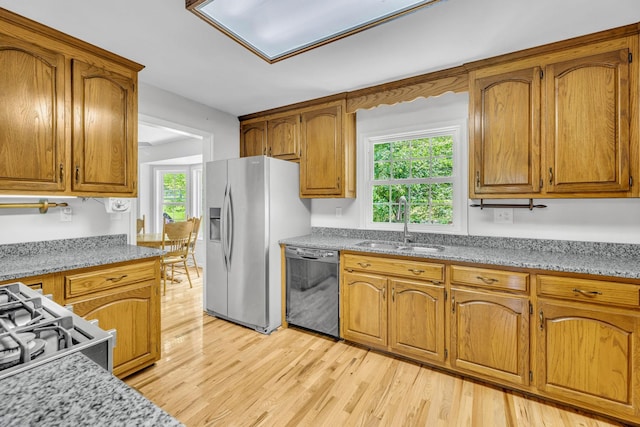 kitchen with stainless steel fridge, black dishwasher, and light stone counters