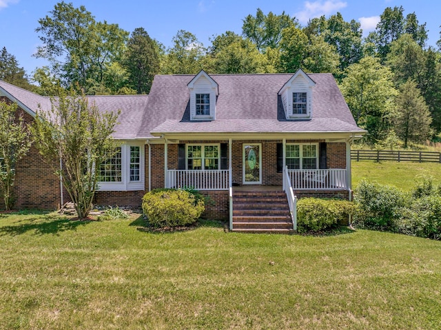 cape cod house with a front yard and a porch