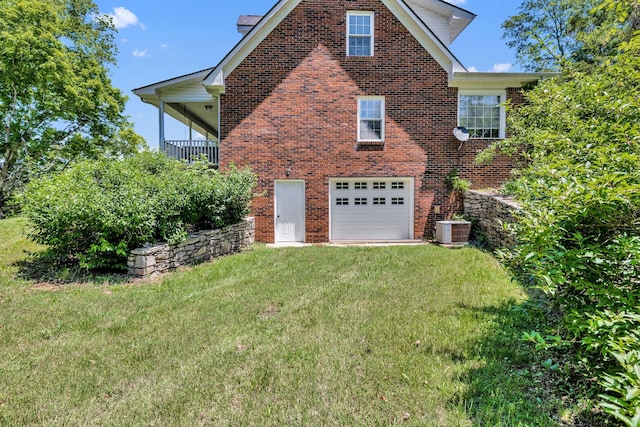 view of side of property with central AC, a garage, and a lawn