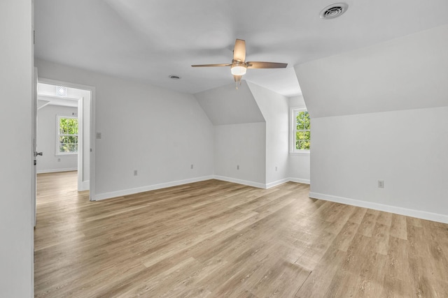 additional living space with ceiling fan, plenty of natural light, vaulted ceiling, and light hardwood / wood-style flooring