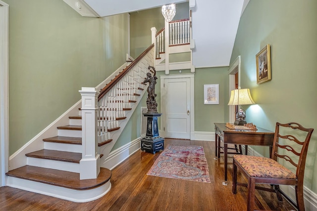 stairs with hardwood / wood-style floors and a high ceiling