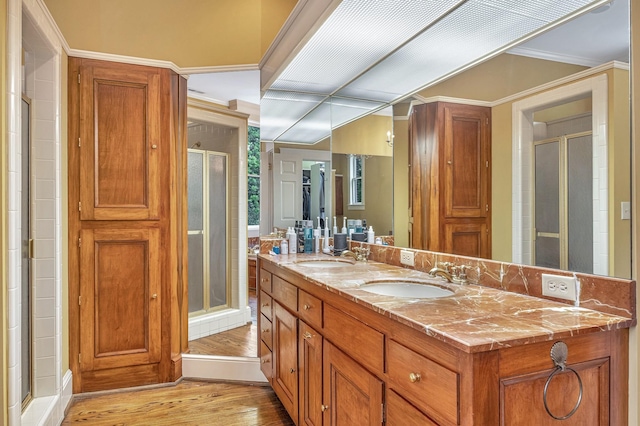 bathroom featuring crown molding, vanity, a shower with shower door, and hardwood / wood-style flooring