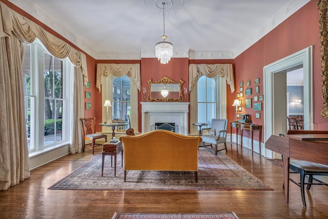 living room with crown molding, wood-type flooring, and a notable chandelier