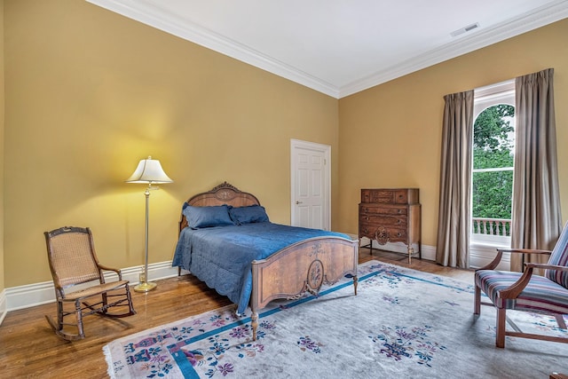 bedroom with hardwood / wood-style floors and crown molding