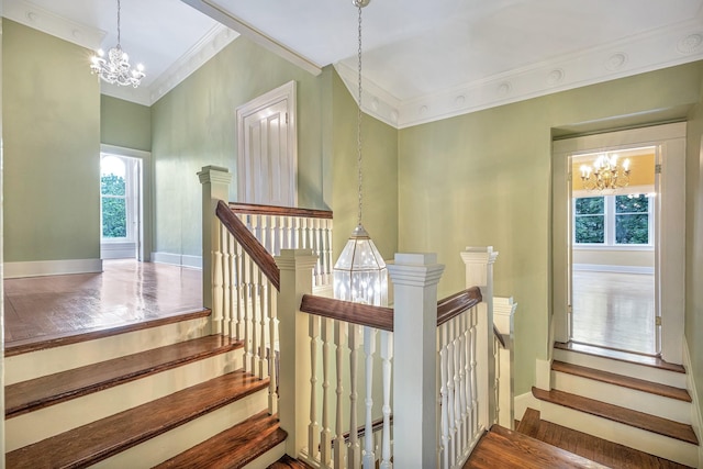 stairs with a chandelier, hardwood / wood-style floors, and crown molding