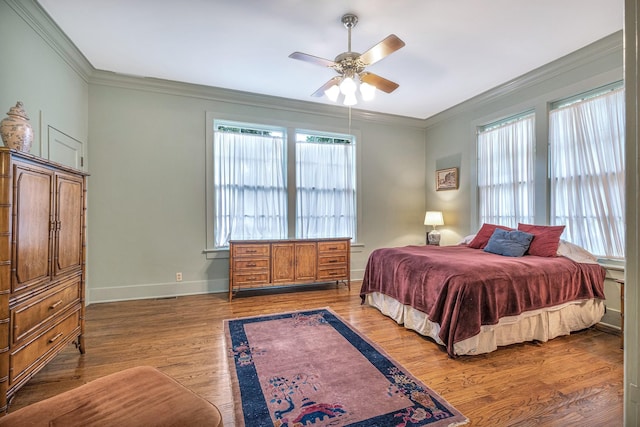 bedroom featuring ceiling fan, crown molding, and light hardwood / wood-style flooring