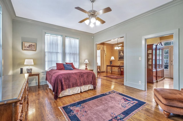 bedroom featuring ceiling fan, wood-type flooring, and ornamental molding