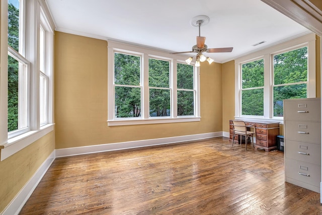 interior space with wood-type flooring, ceiling fan, and ornamental molding