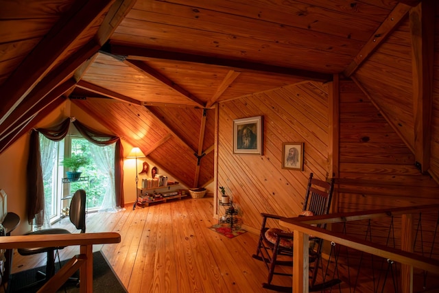 interior space featuring lofted ceiling with beams, wood walls, wooden ceiling, and light wood-type flooring