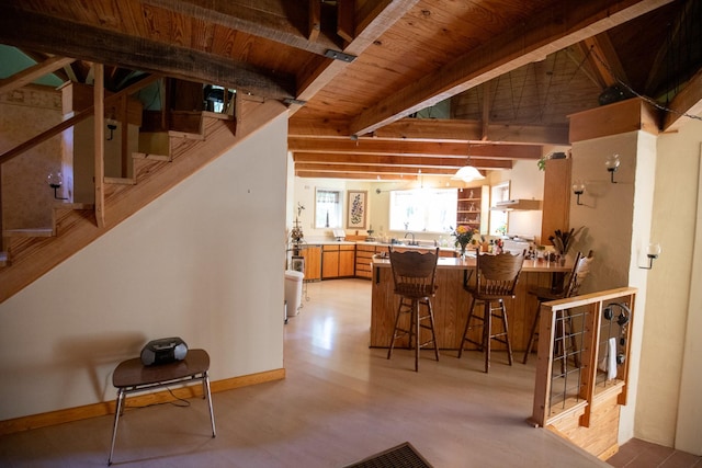 dining area featuring sink, beamed ceiling, wood ceiling, and light hardwood / wood-style flooring