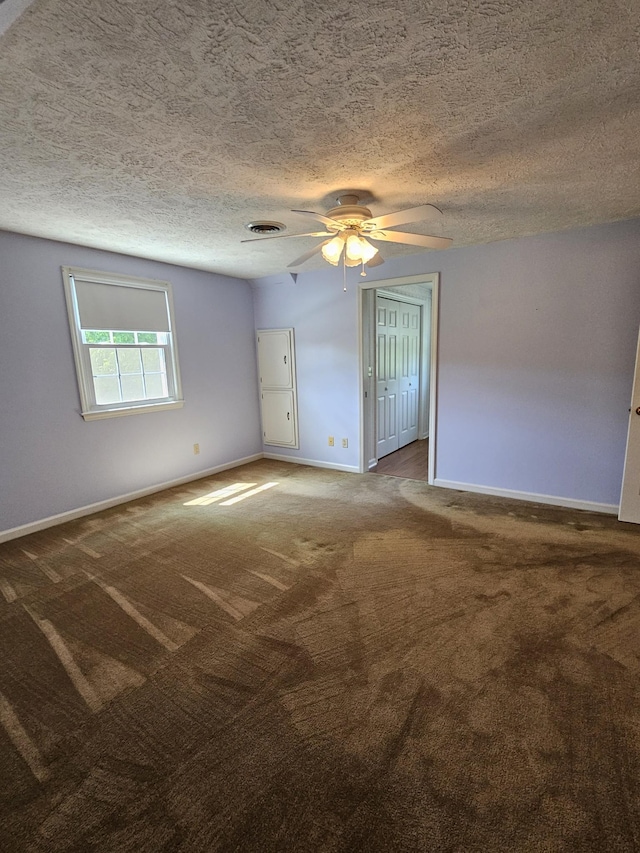 empty room with carpet flooring and a textured ceiling