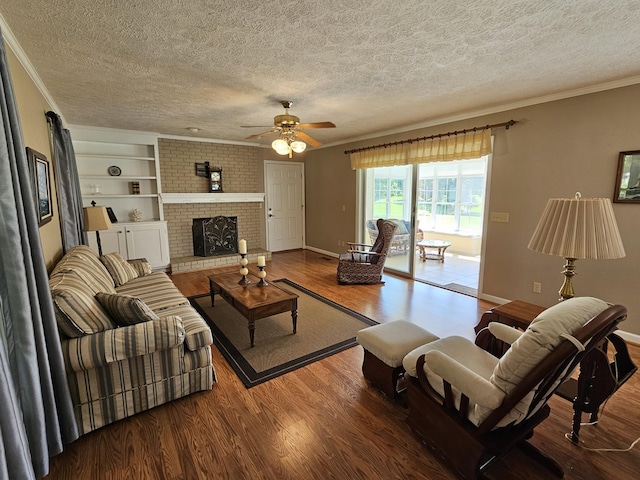 living room featuring crown molding, a brick fireplace, hardwood / wood-style flooring, ceiling fan, and a textured ceiling