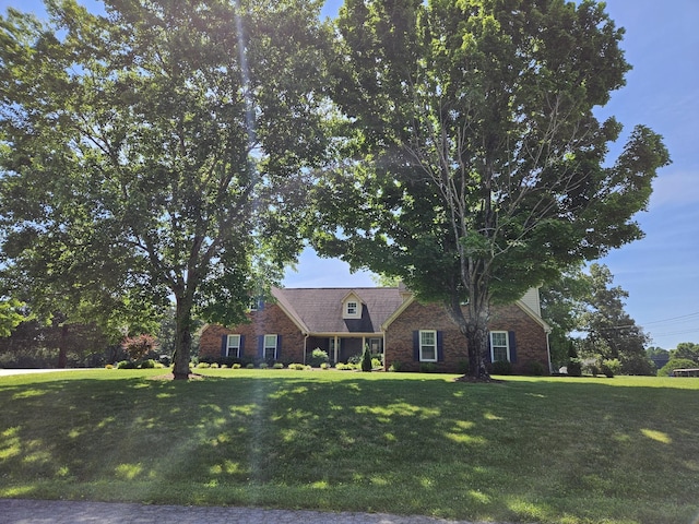 cape cod home featuring a front lawn