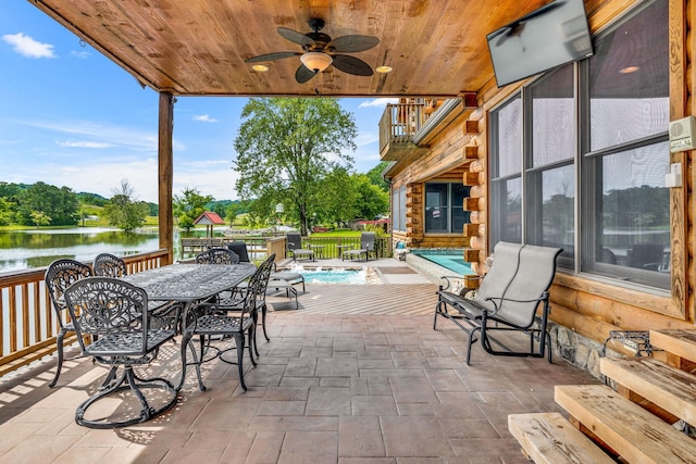 view of patio featuring a balcony, ceiling fan, and a water view