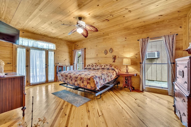 bedroom with a wall unit AC, light hardwood / wood-style floors, wooden walls, ceiling fan, and wooden ceiling