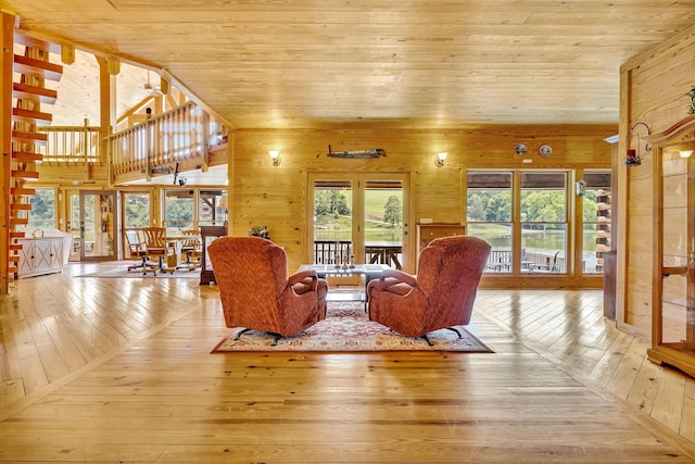 living room featuring light hardwood / wood-style floors, wooden walls, a healthy amount of sunlight, and wood ceiling