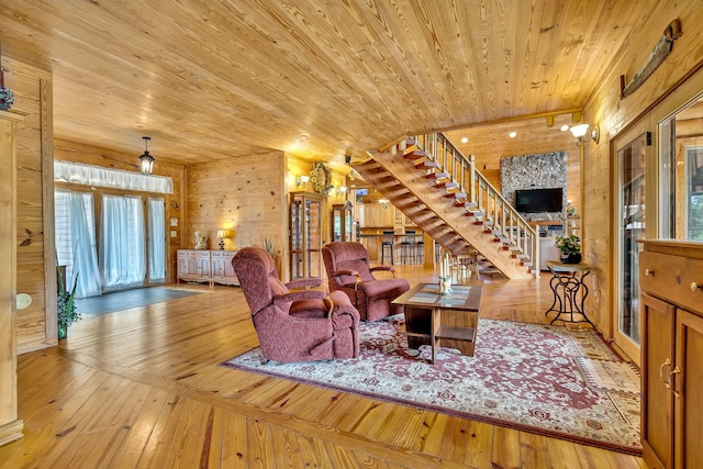 living room with wooden walls, light hardwood / wood-style floors, and wood ceiling