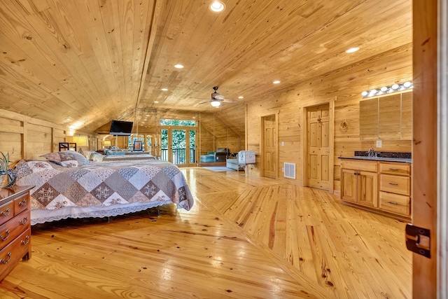 bedroom featuring wood walls, wood ceiling, lofted ceiling, light wood-type flooring, and sink