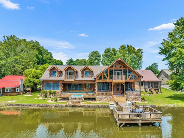 rear view of house featuring a yard, a balcony, and a deck with water view