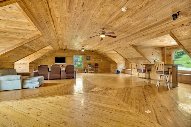 additional living space featuring wooden walls, wooden ceiling, lofted ceiling, and plenty of natural light