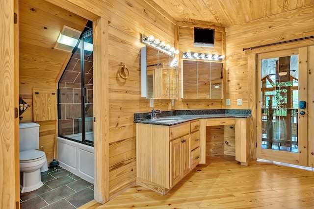 full bathroom featuring wooden ceiling, toilet, vanity, bath / shower combo with glass door, and wooden walls